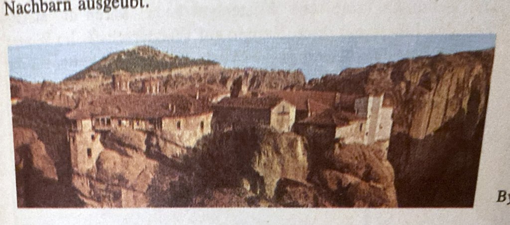 Panoramablick auf ein Kloster, das auf einer Felsformation gebaut ist, umgeben von Bergen und Lagern der natürlichen Umgebung.
