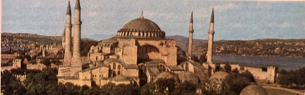 Die Hagia Sophia in Istanbul, umgeben von Minaretten und der Landschaft, mit Blick auf das Wasser im Hintergrund.
